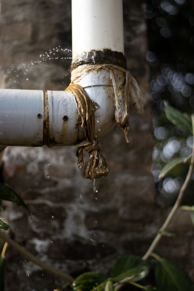 Water leaking from a joint in a pipe running down a wall