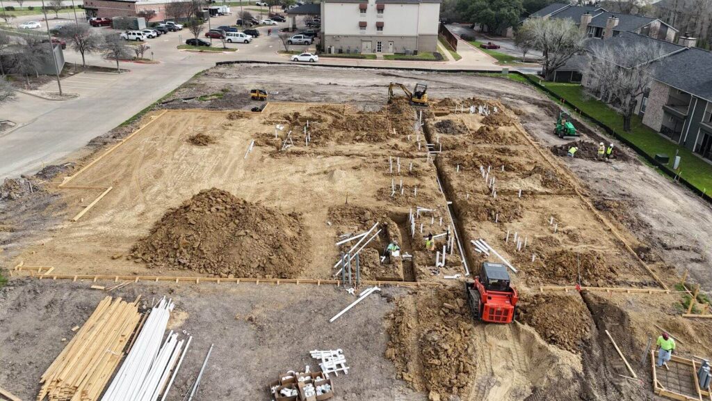 Aerial view of underground plumbing trenches on a commercial building pad