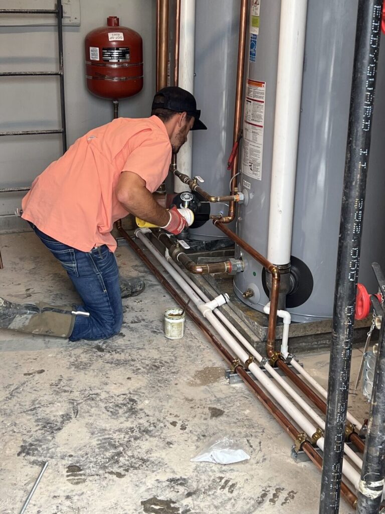 A plumber connecting pipework to a newly installed water heater