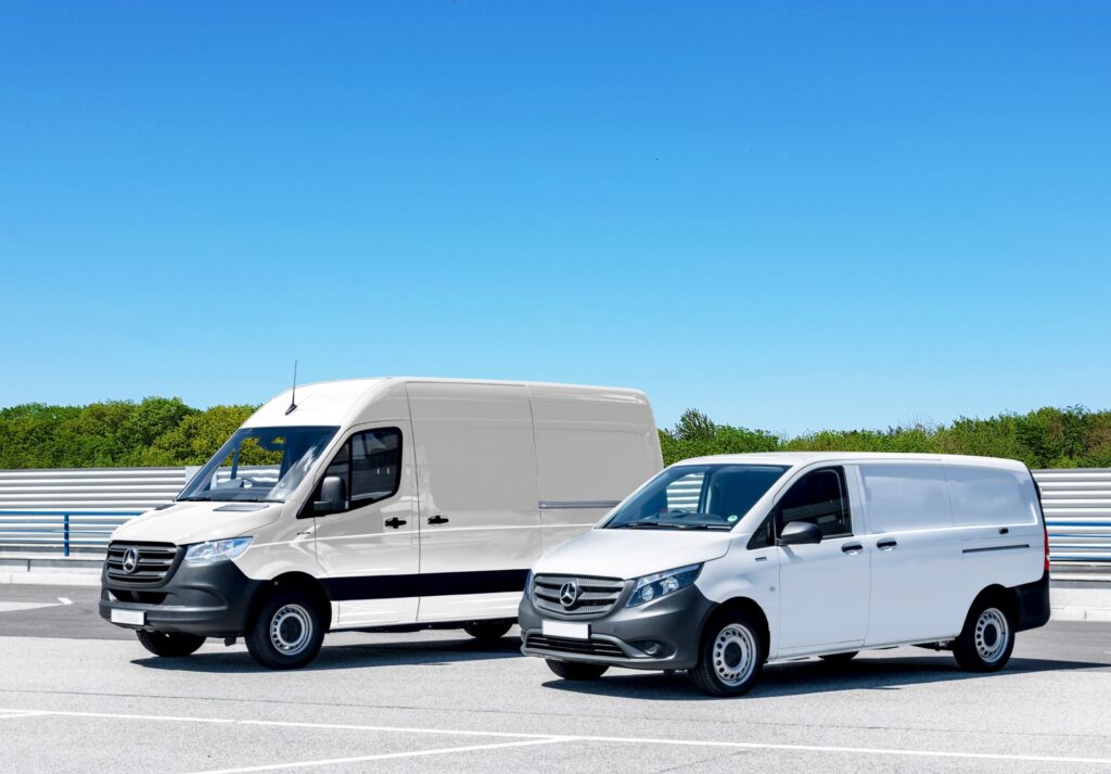 Two white work vans parked outside