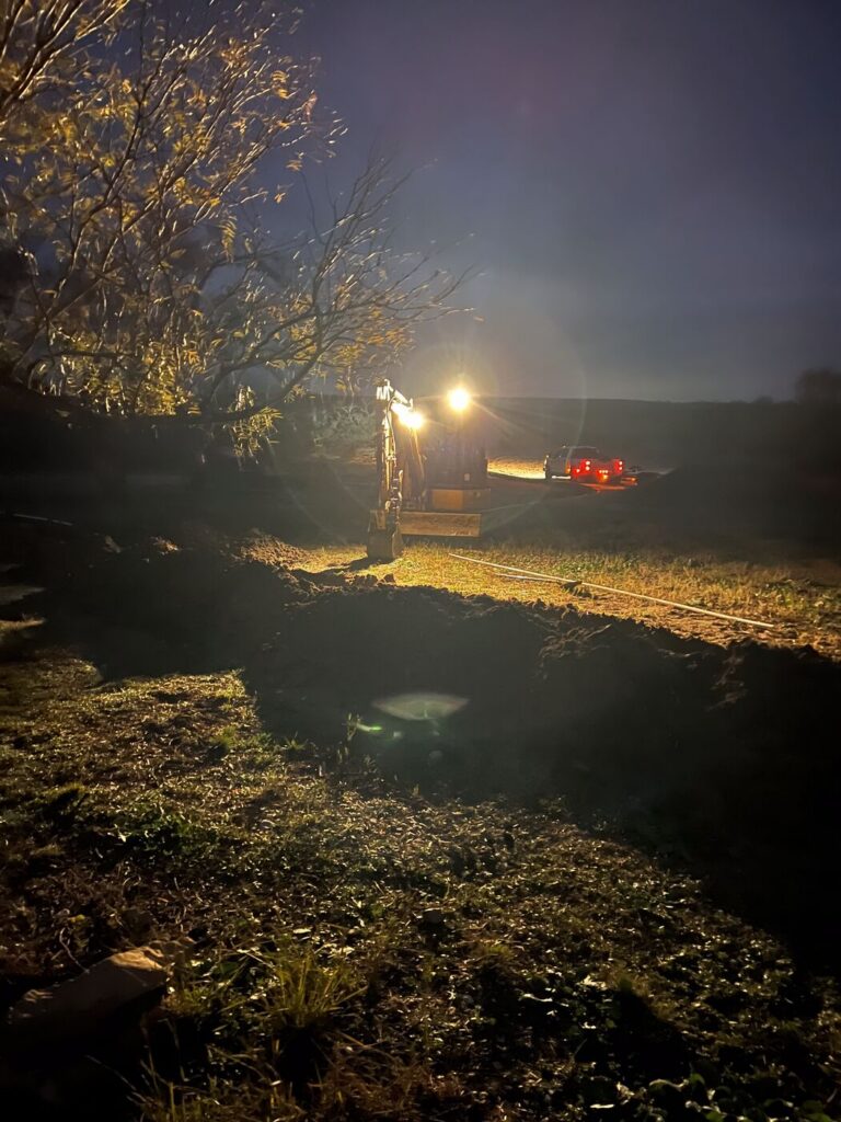 A water line repair being carried out under lights at night