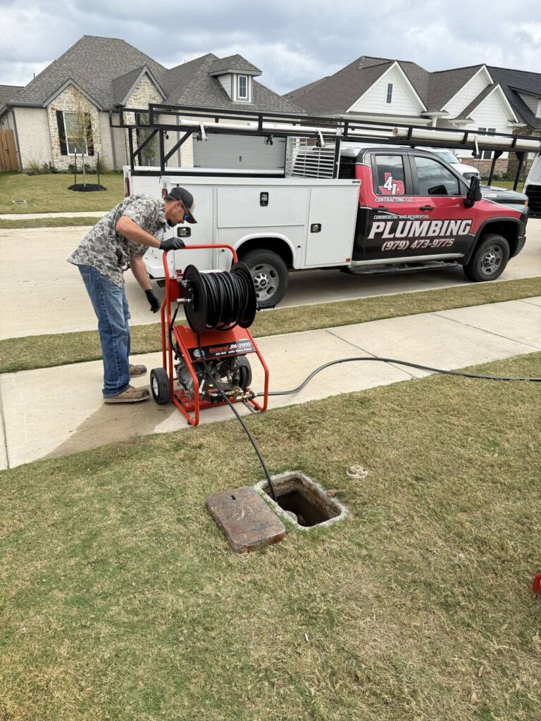 A jetter and hose reel working at a cleanout in a front lawn