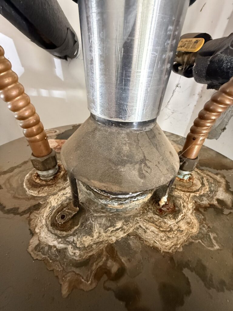 Heavy mineral scale built up around the base of a water heater